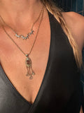 close up of star shaped necklace on a person wearing another necklace below it