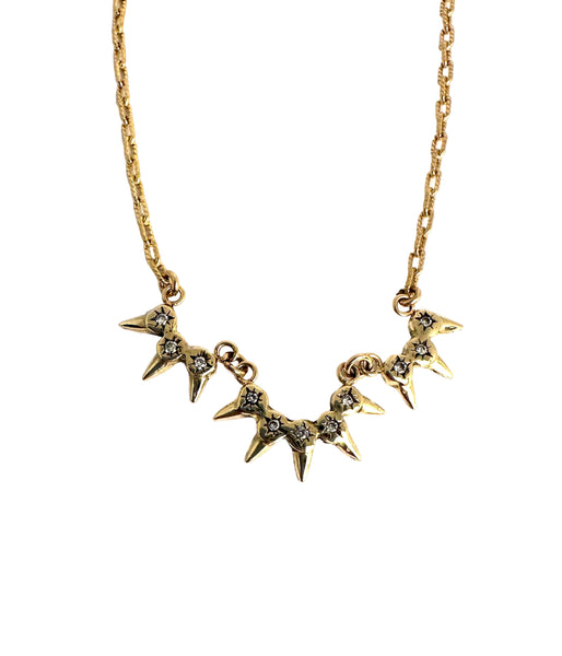 Gold diamond necklace with 3 star-shaped pendants on a white background